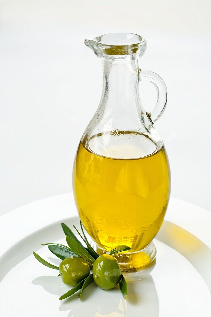 Olivenöl in Karaffe, grüne Oliven