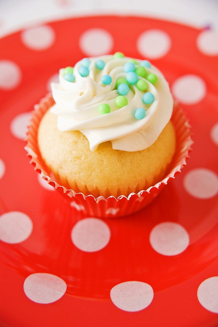 A vanilla cupcake with sugar balls