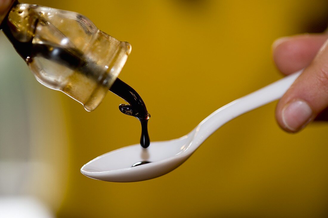 Balsamic vinegar being drizzled onto a spoon