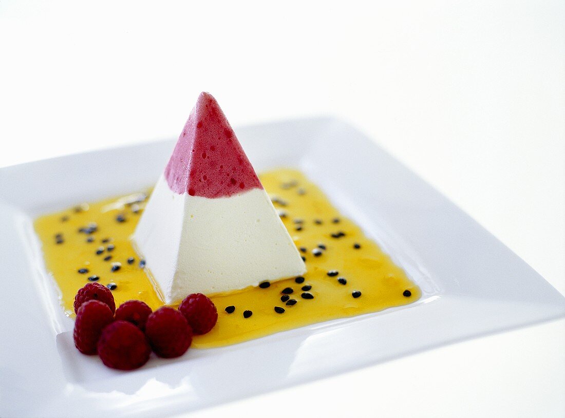 Parfait pyramid with fruit sauce and raspberries