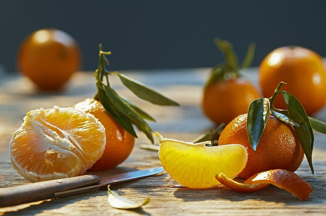 Tangerines with leaves, partially peeled