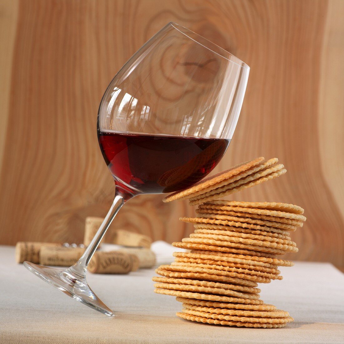 A glass of red wine and a stack of biscuits