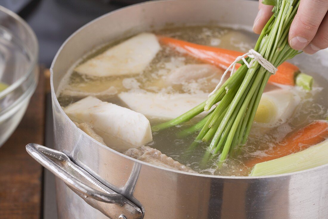 Putting soup vegetables into a pot