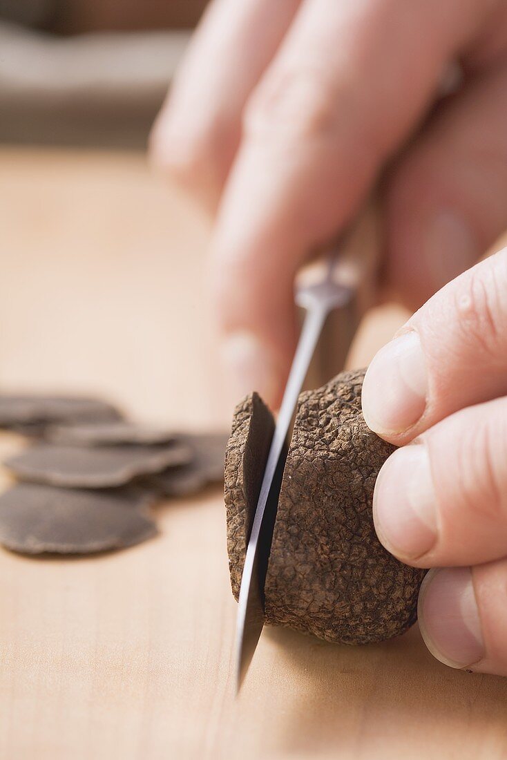 A black truffle being sliced