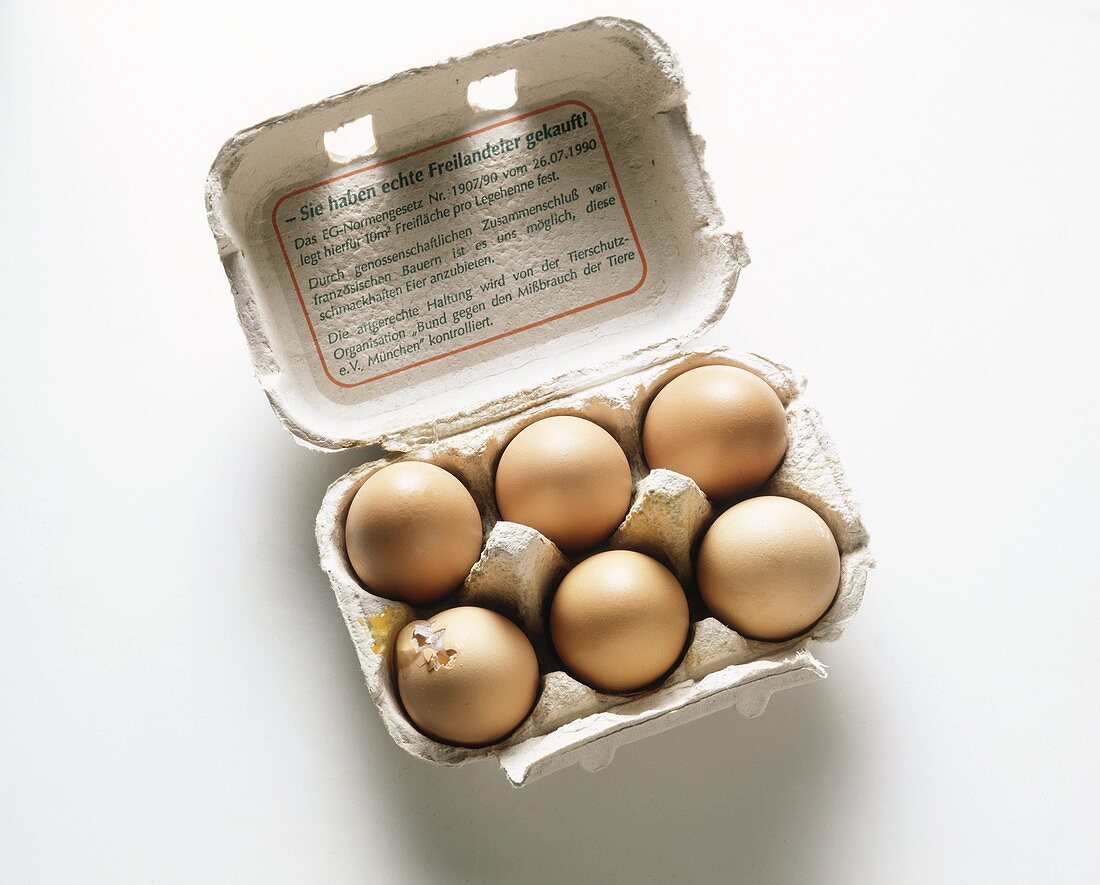 Sechs Eier in der Schachtel; ein Ei kaputt
