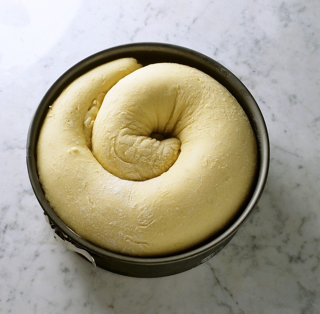 Placing Reindling (yeast cake with nut filling)in baking tin