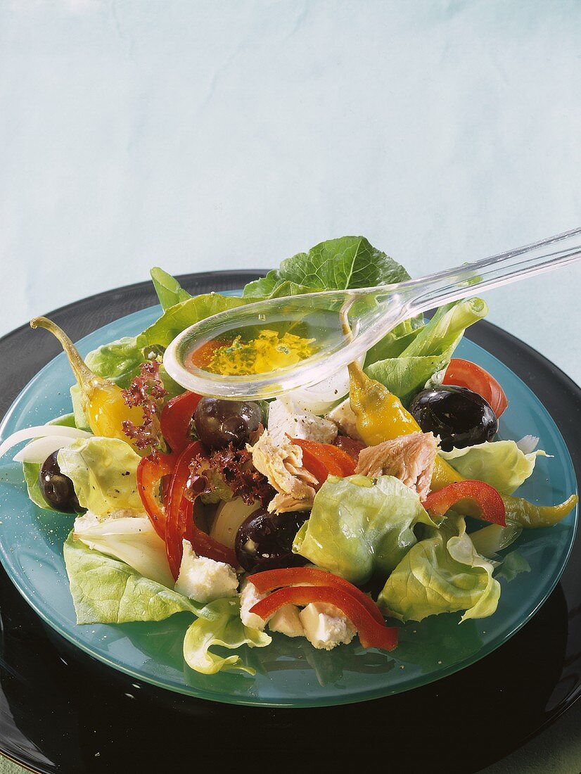 Pouring Vinaigrette Sauce over Tuna Salad