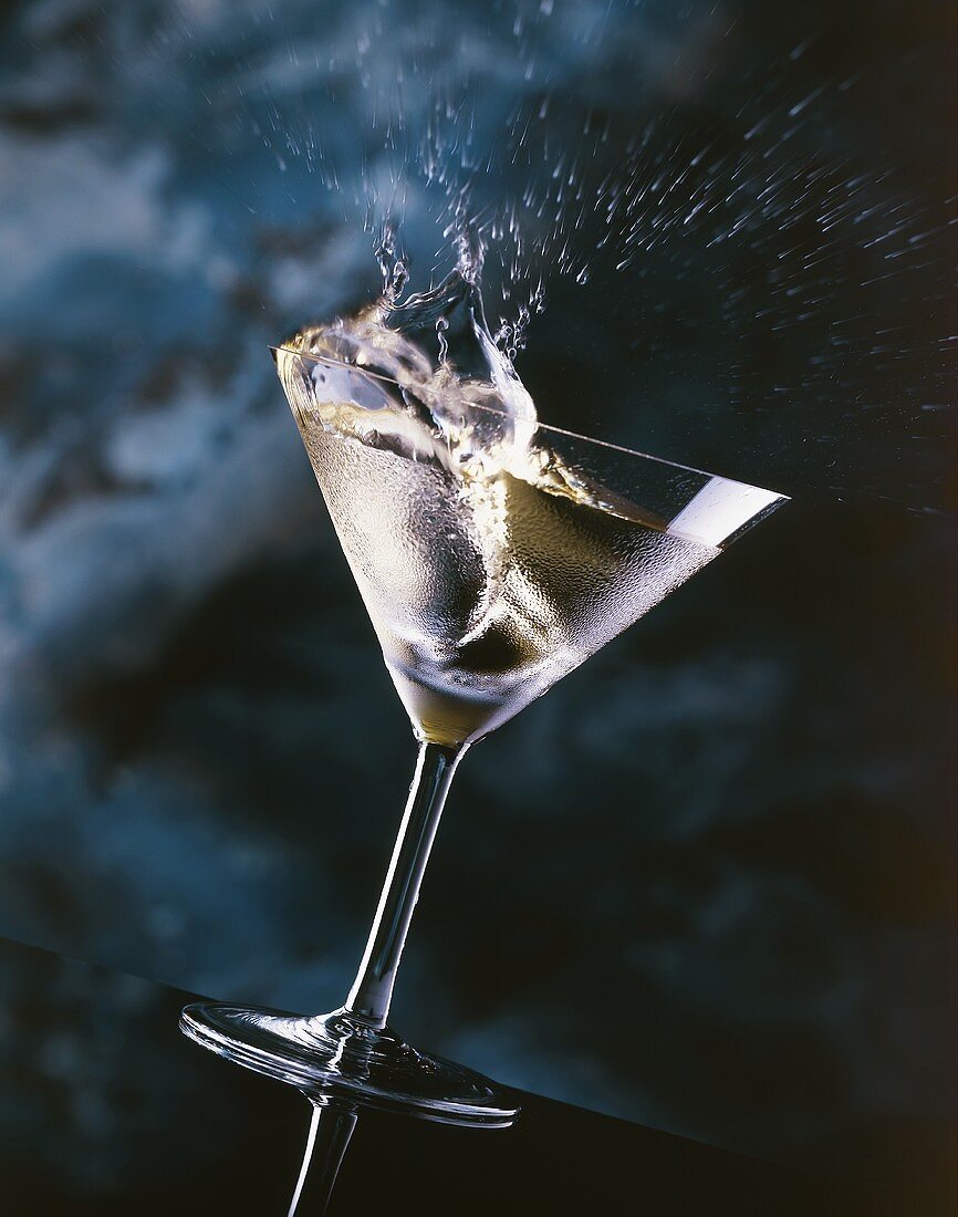 Ice-cold Martini splashing out of a glass