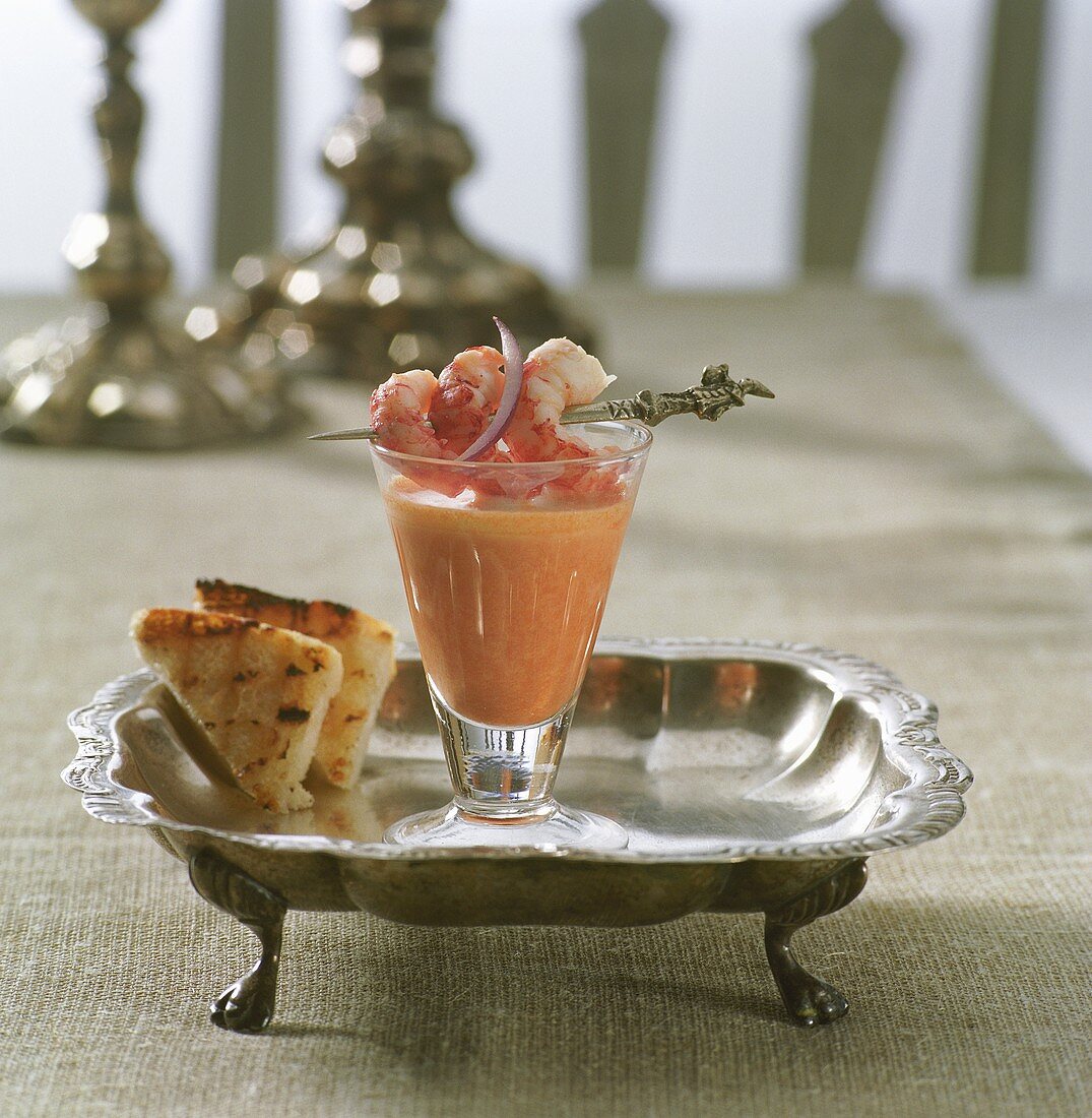 Shrimp soup in a glass with skewered shrimp