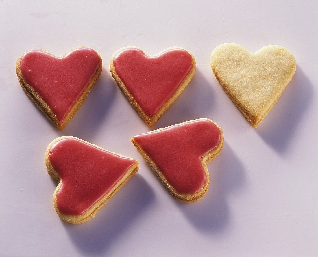 Five heart-shaped biscuits with mango icing