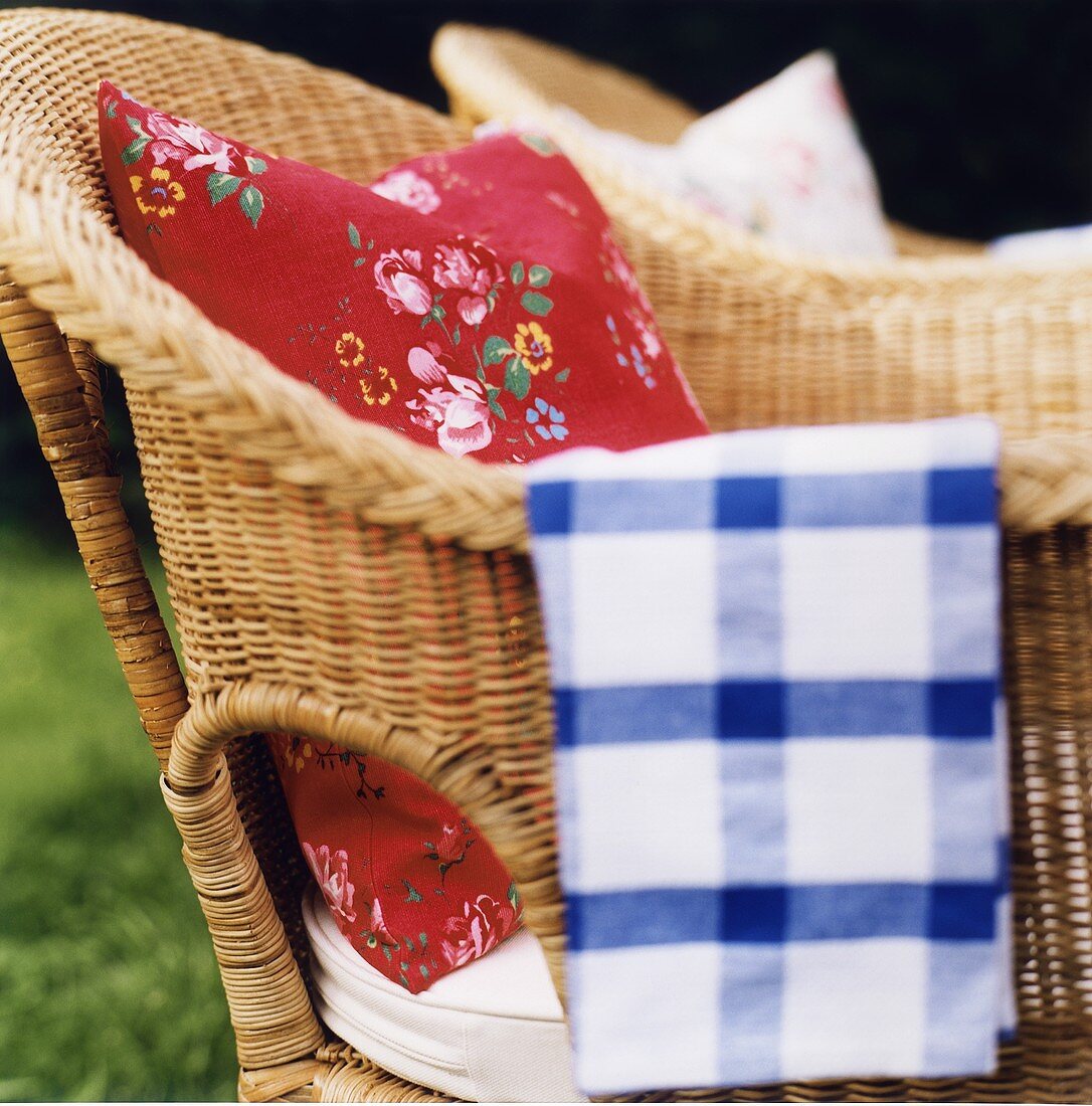 Two rattan chairs with cushions in a garden