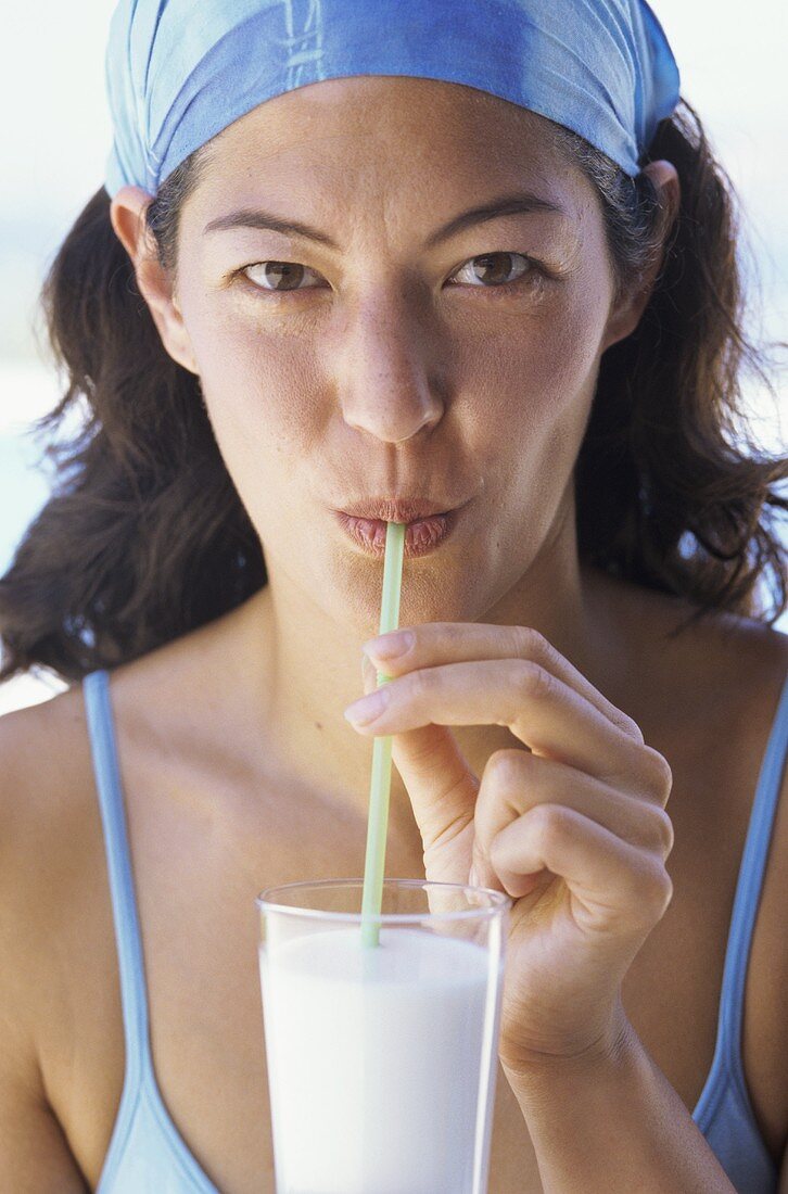 Junge Frau trinkt Milchshake mit Strohhalm