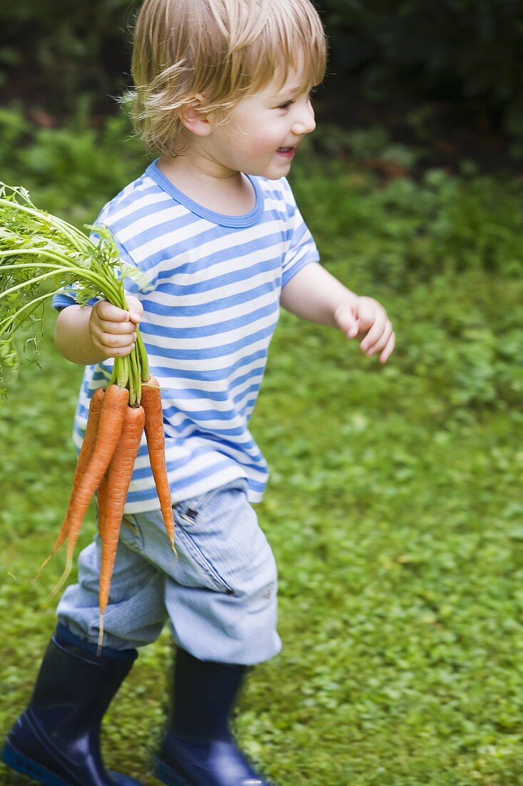 Boy running with carrots in his hand