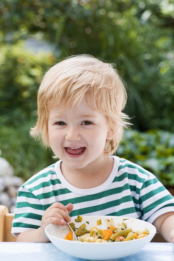 Kleiner Junge isst Gemüsesuppe