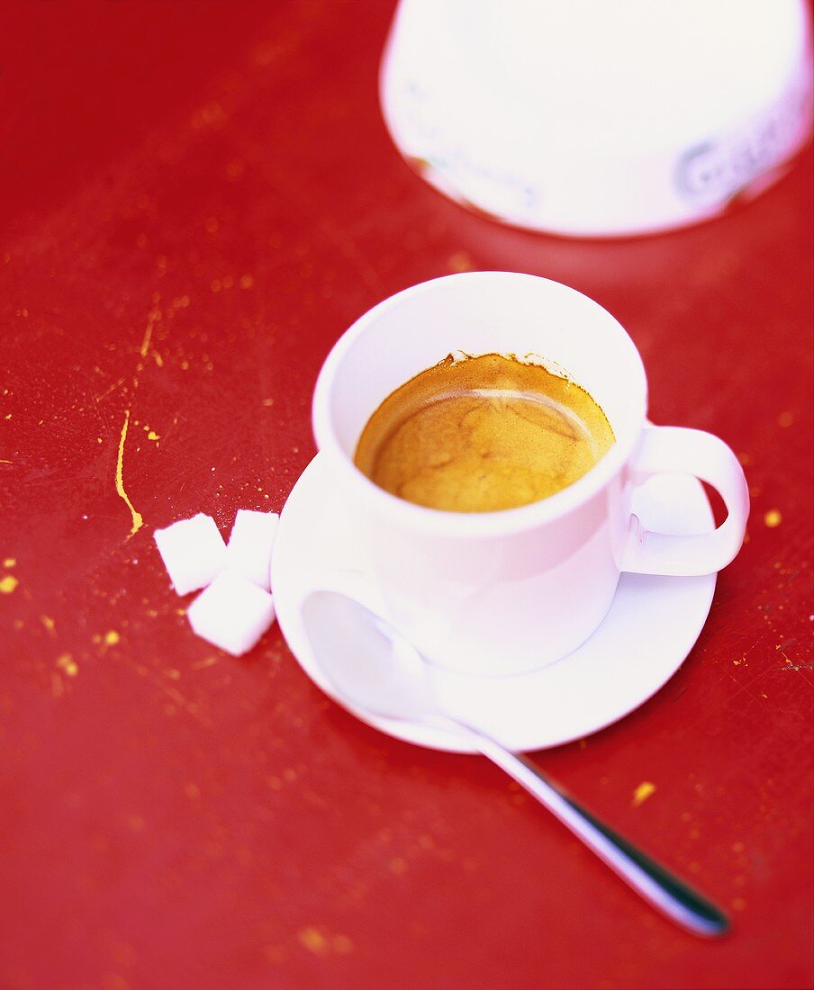 Espresso in white cup; sugar cubes