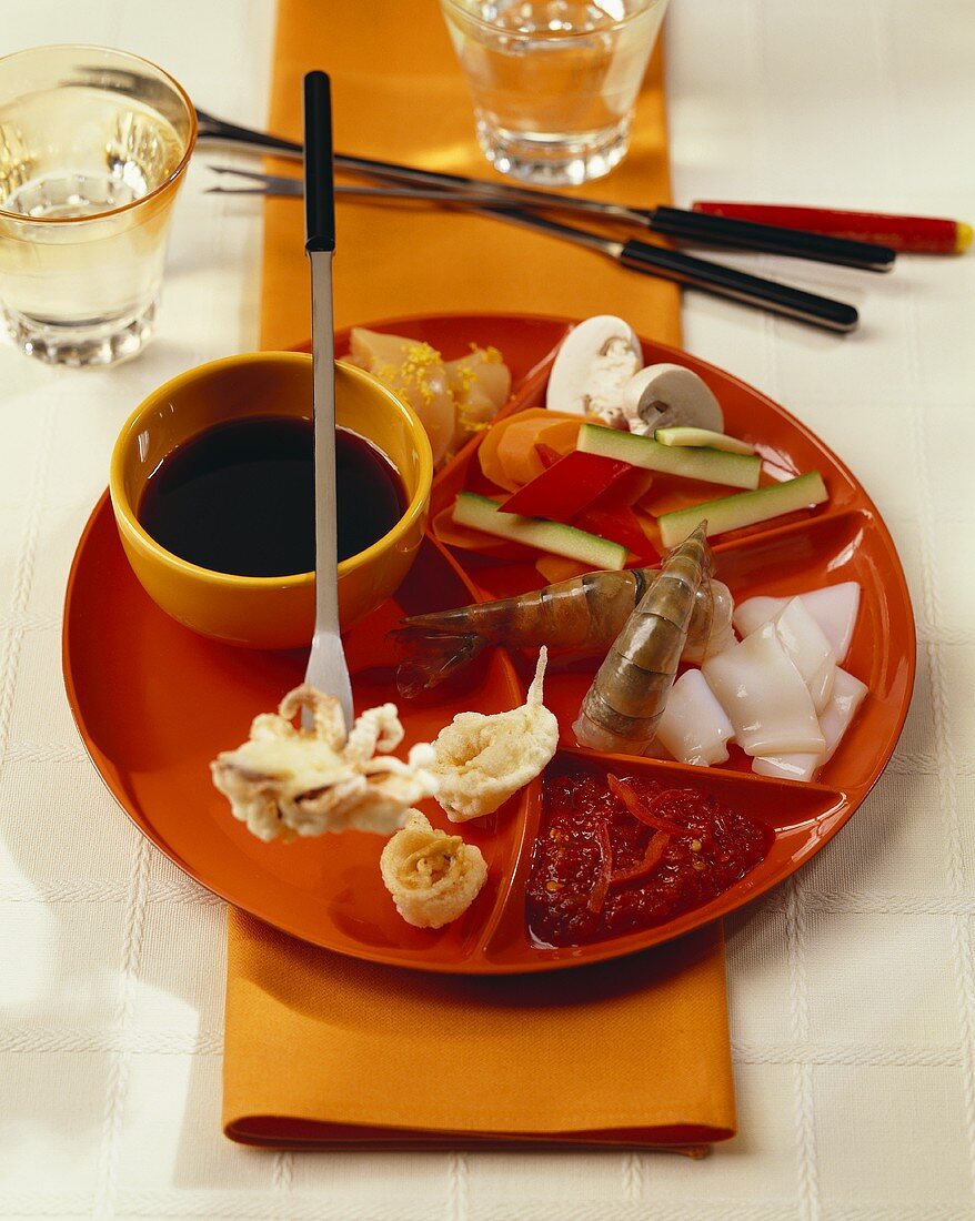 Fondue with seafood, vegetables and dips (Asia)
