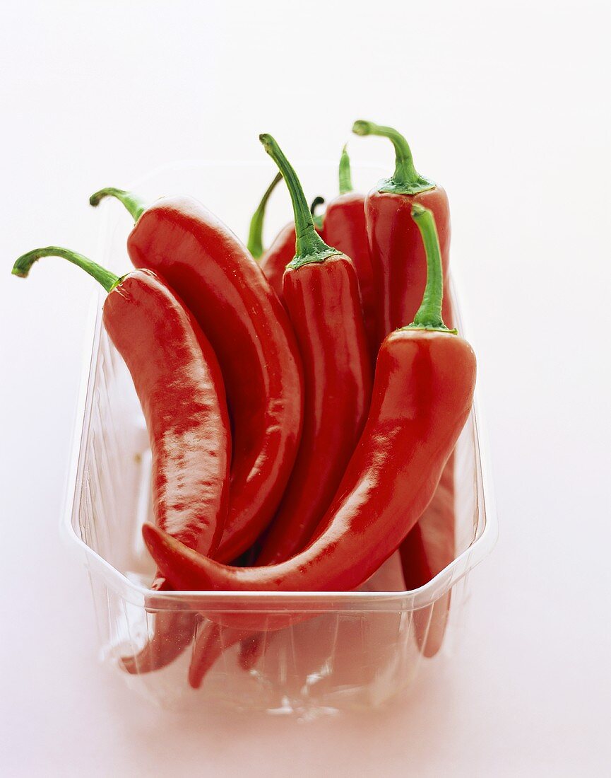 Fresh red chili peppers in plastic container