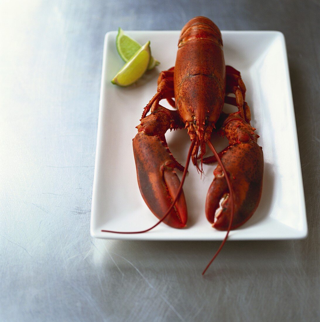 Cooked lobster with wedges of lime