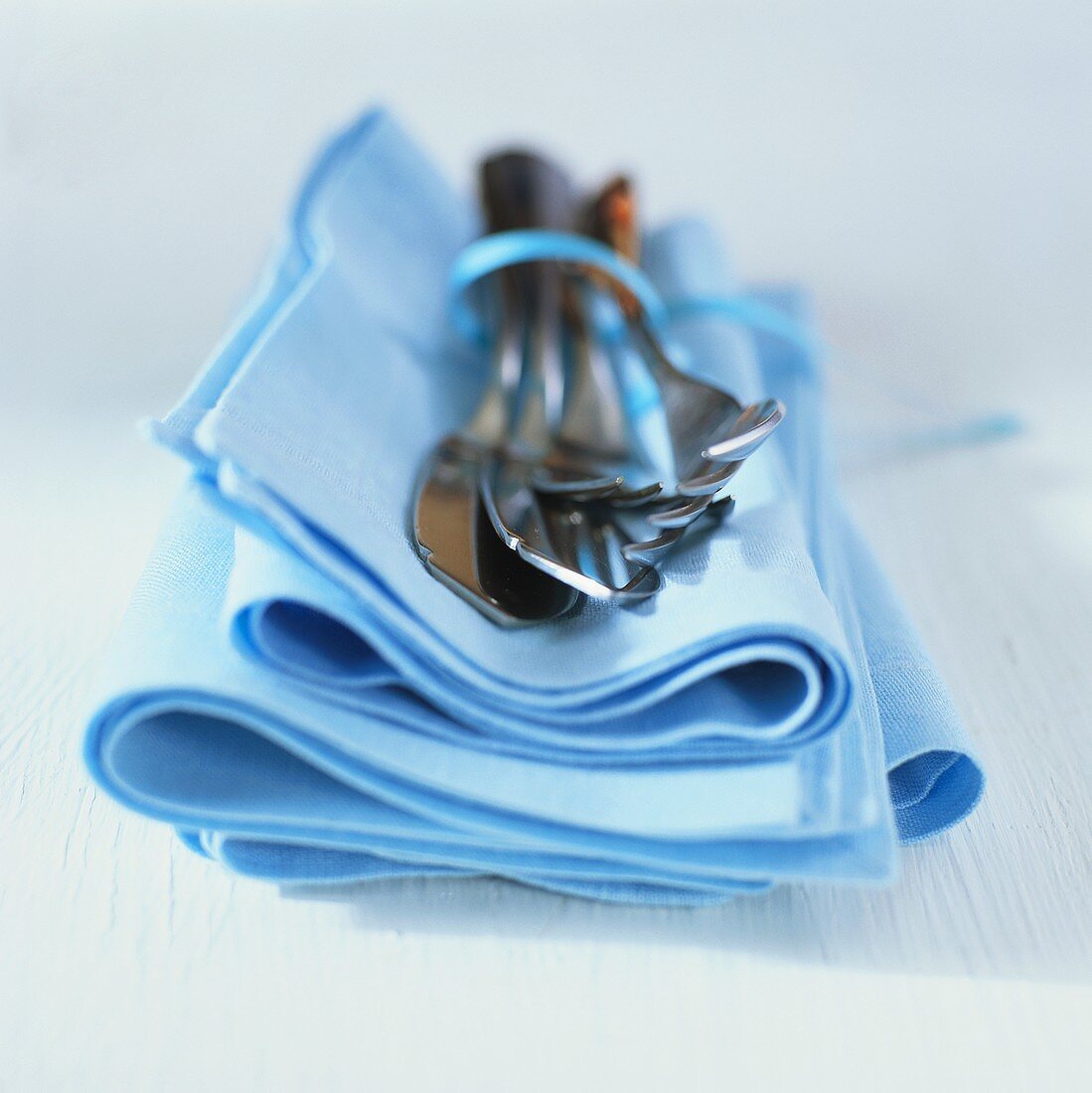 Cutlery on pale-blue fabric napkin