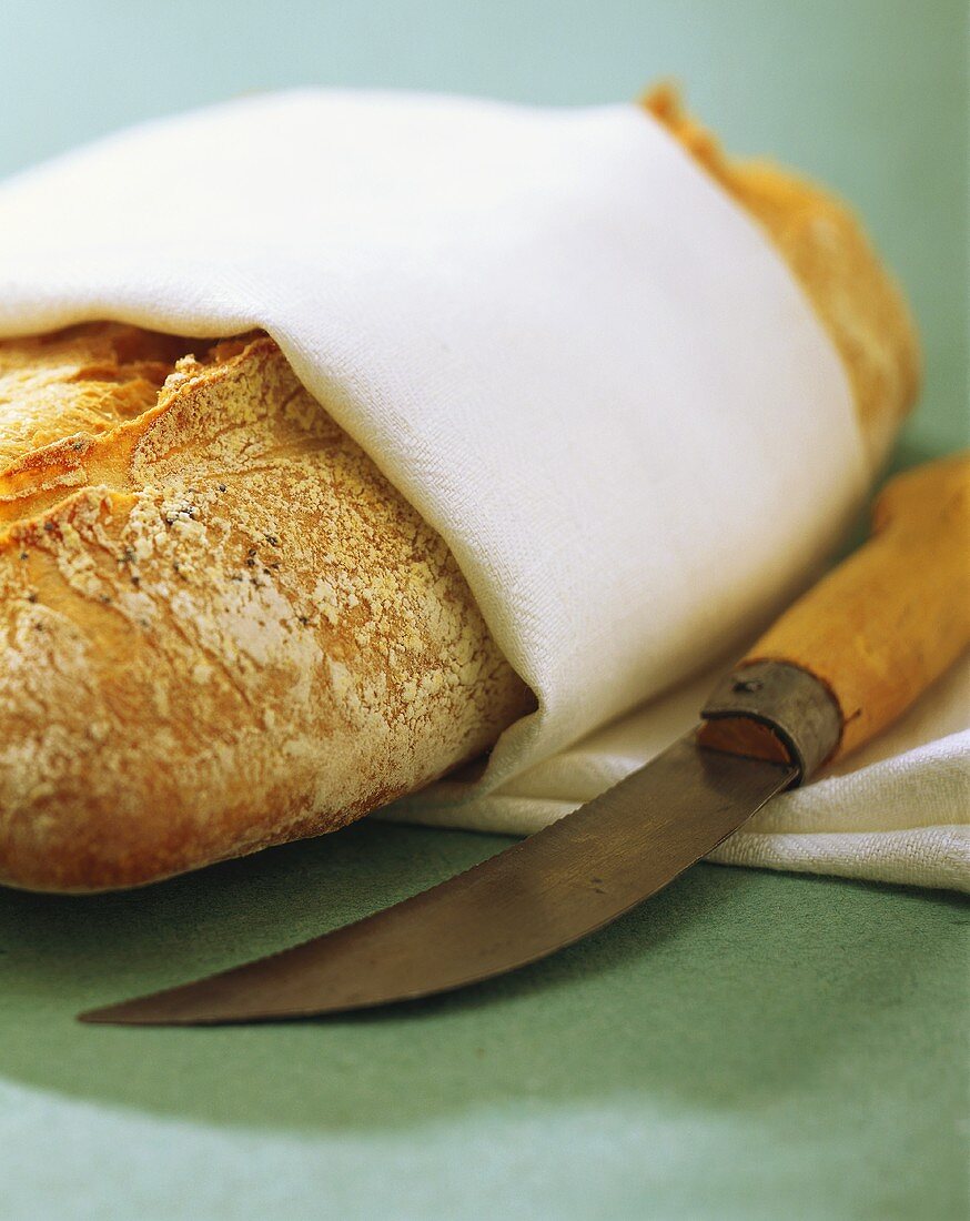 Bread with white tea towel and knife