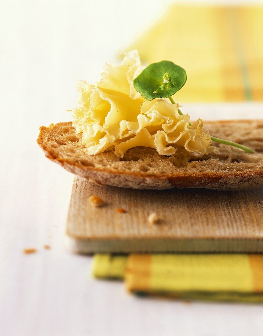 Brot mit Bergkäse auf Holzbrett