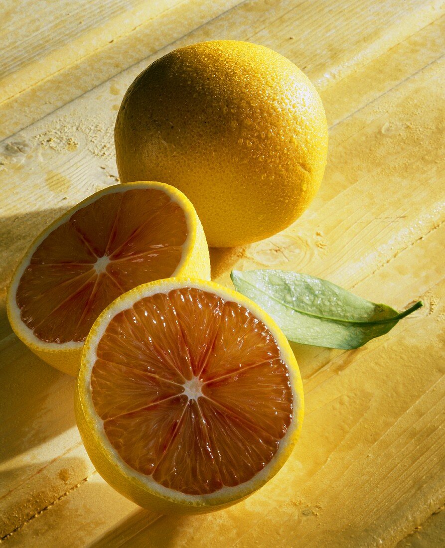 Blood orange (Citrus sinensis), whole and halved
