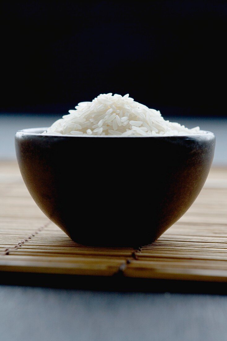 Brown bowl full of long-grain rice