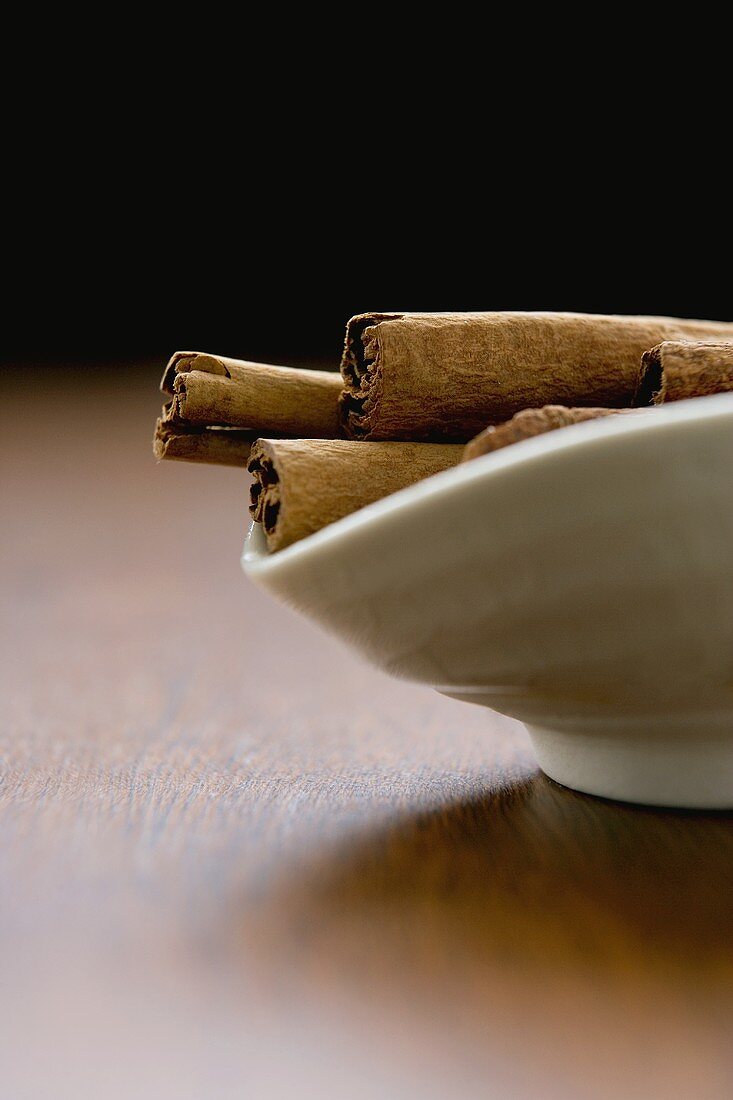 Cinnamon sticks in small white bowl