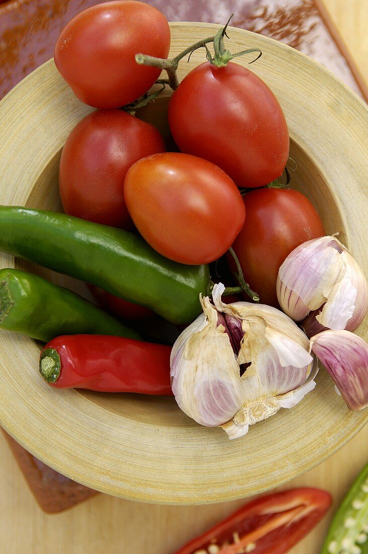 Tomatoes, chili peppers and garlic on plate