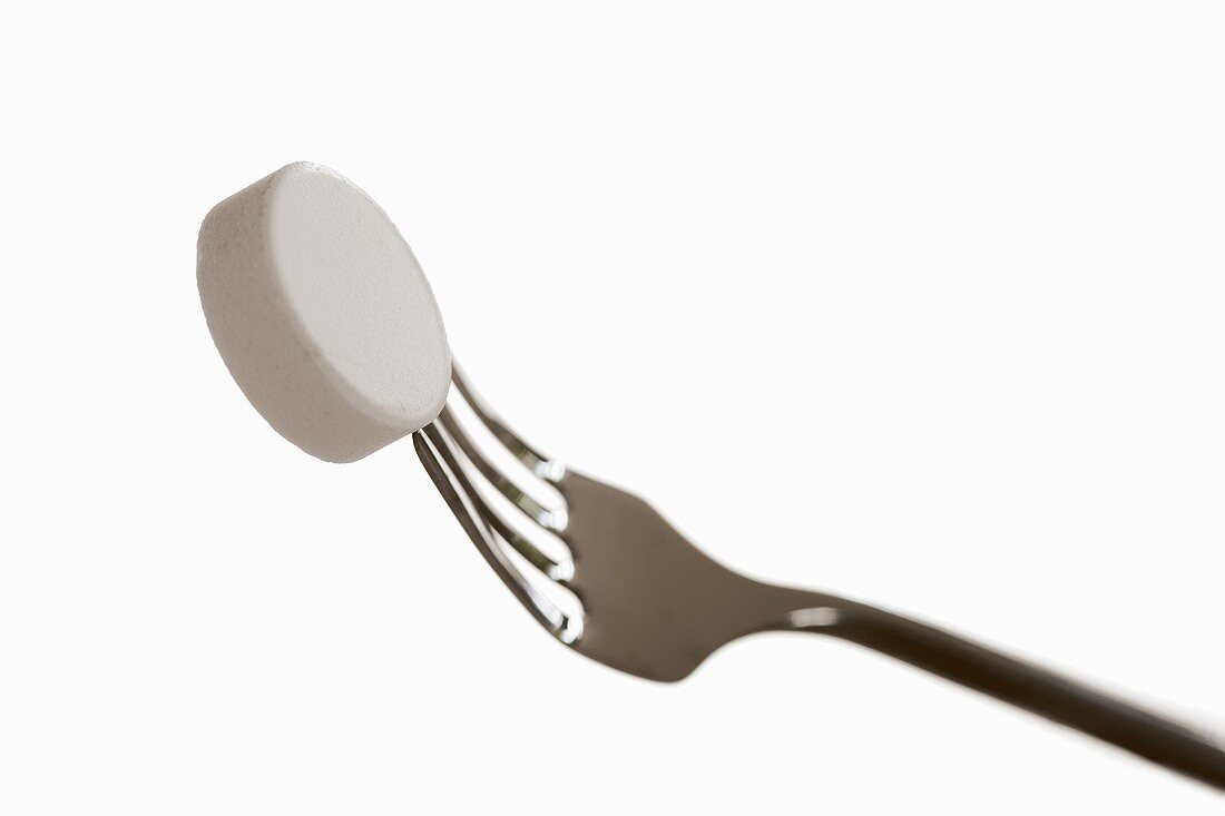 White tablet on fork