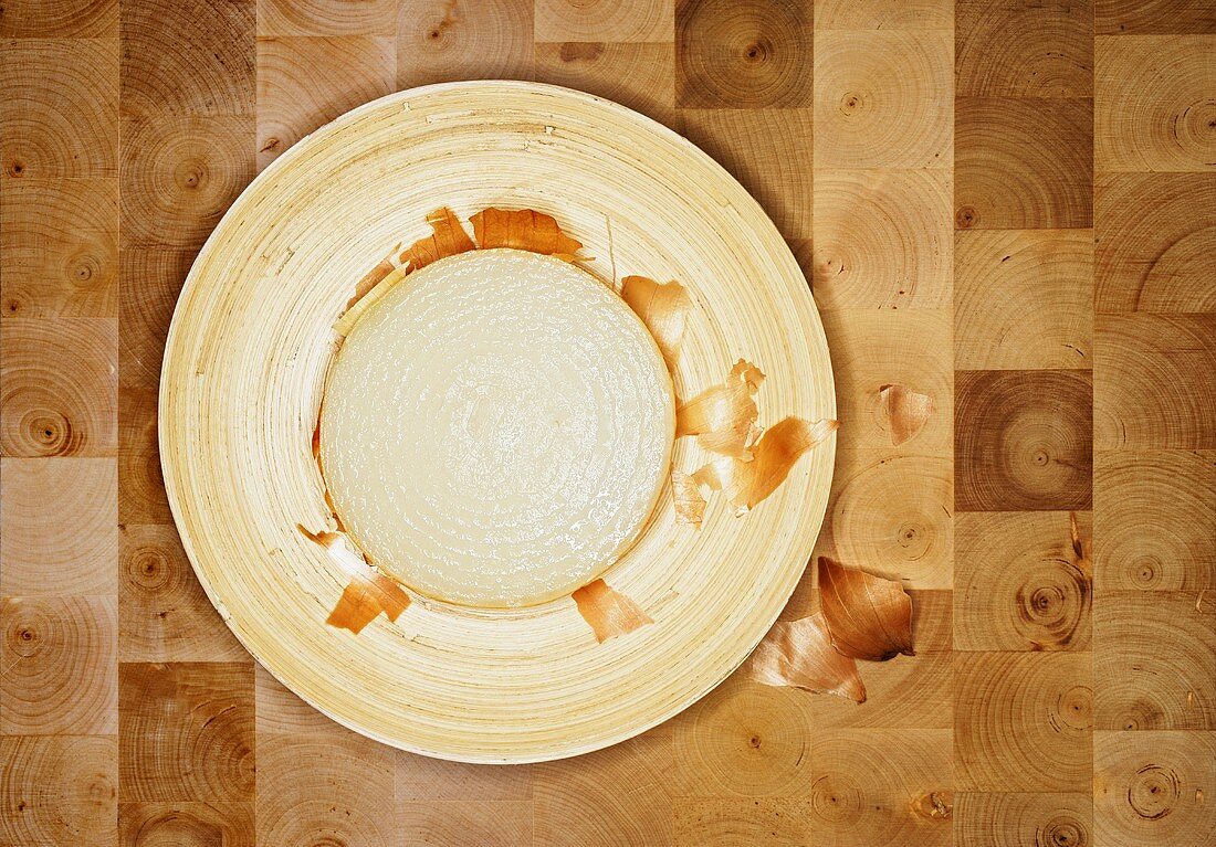 Slice of white onion and onion skin on plate