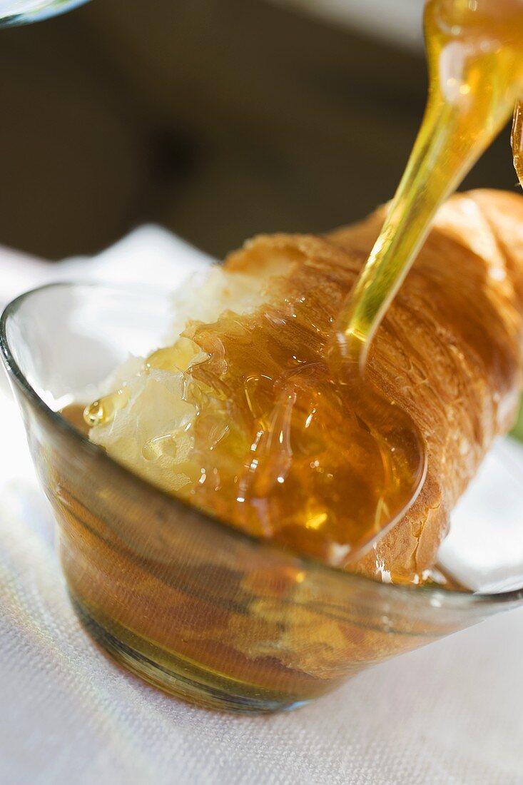 Honey running onto croissant