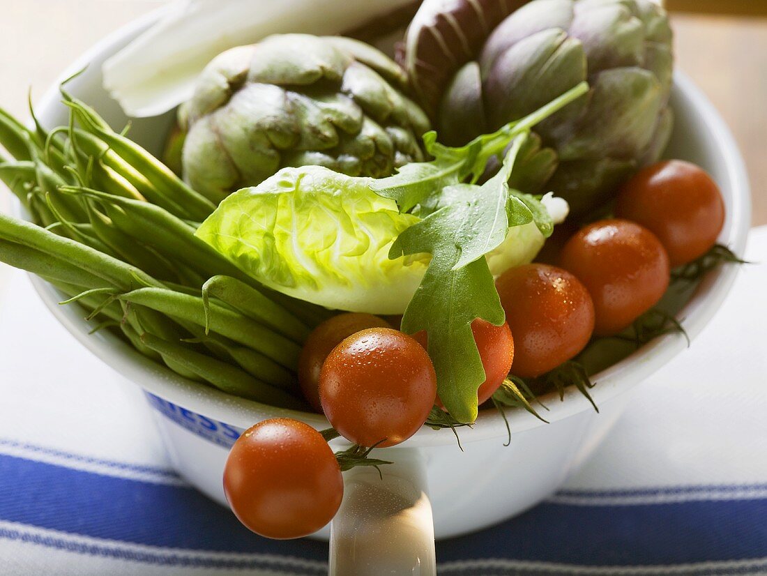 Fresh vegetables and salad in strainer