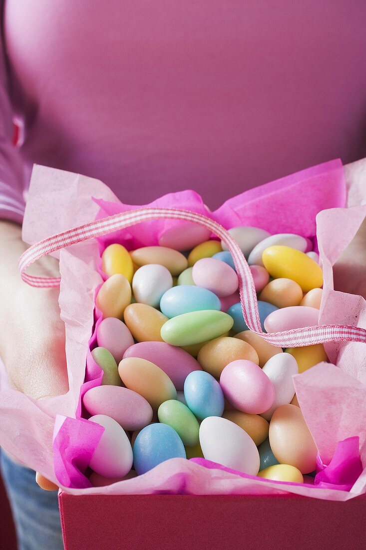 Hands holding box of sugared almonds