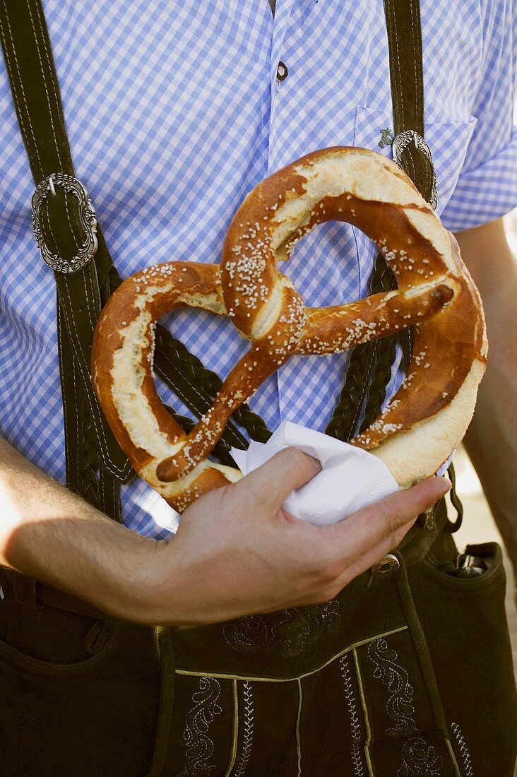 Man in national dress with pretzel (Oktoberfest, Munich)