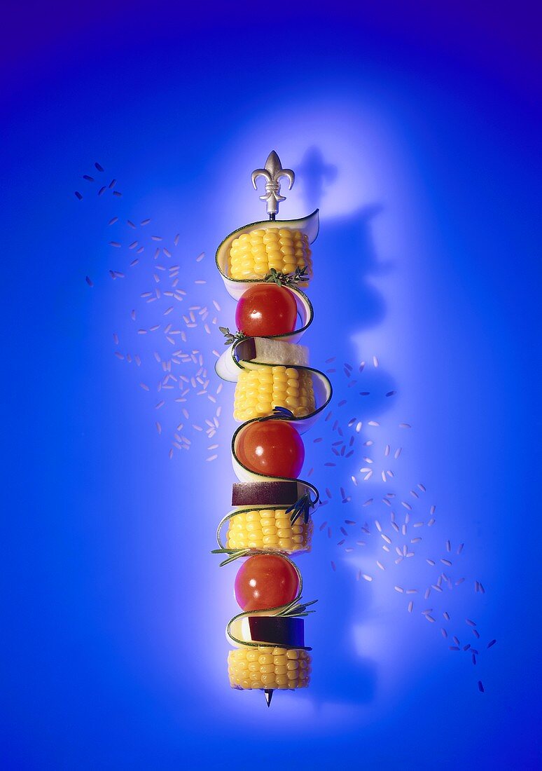 Raw vegetable skewer with corn on the cob and herbs