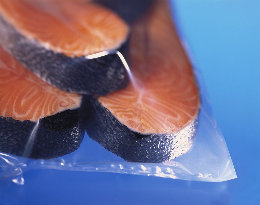Three fresh salmon steaks in freezer bag