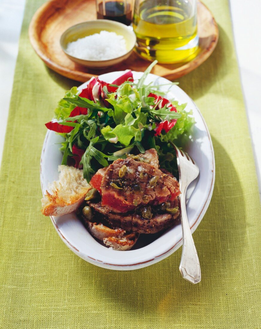 Tuna steaks with olives, capers and salad
