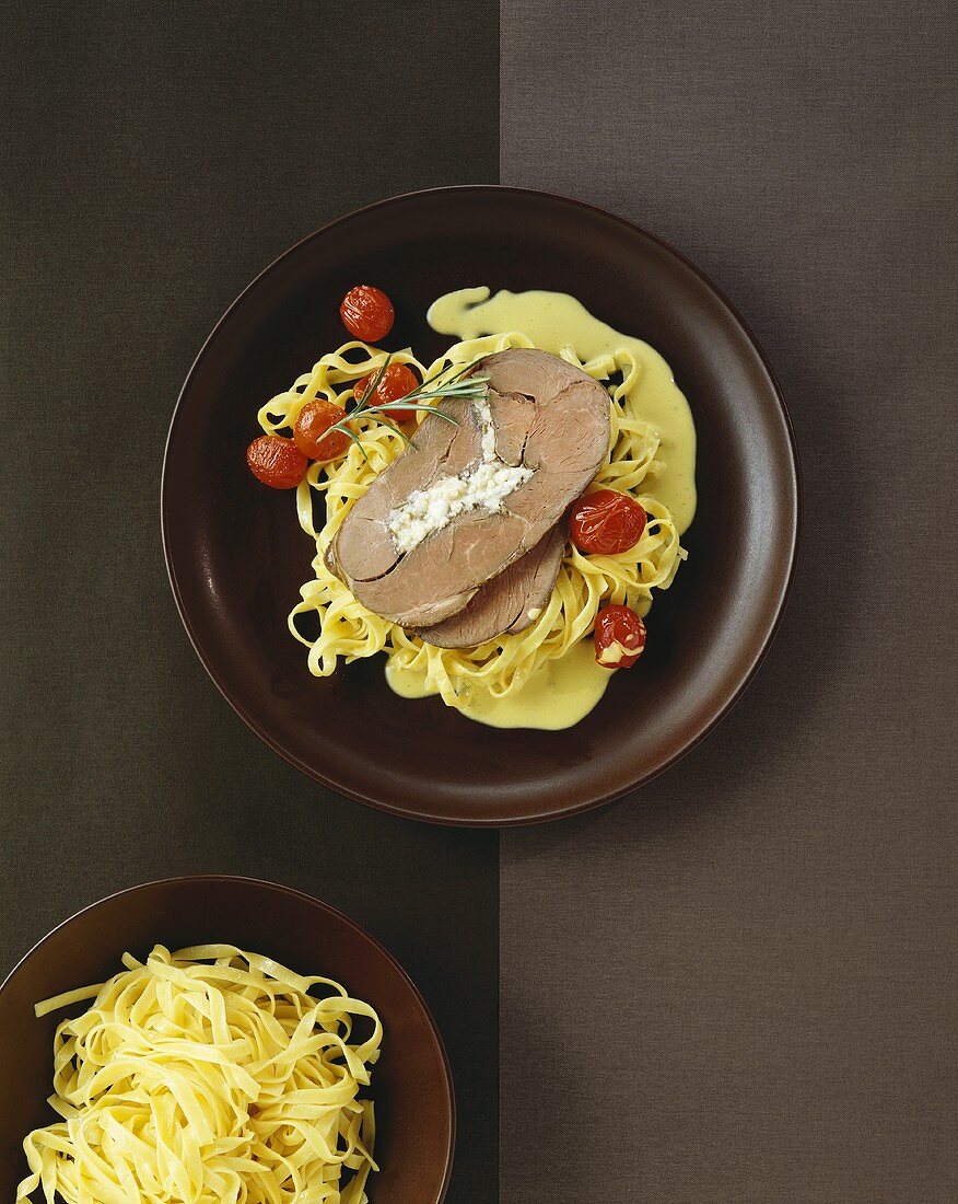 Stuffed leg of lamb on ribbon pasta with cherry tomatoes