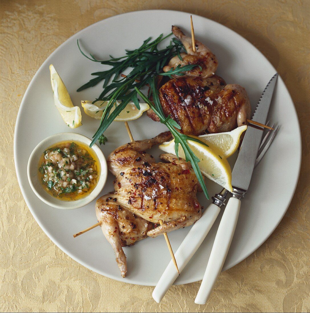 Gegrillte Stubenküken, Kräuteröl, Zitronen und Rucola