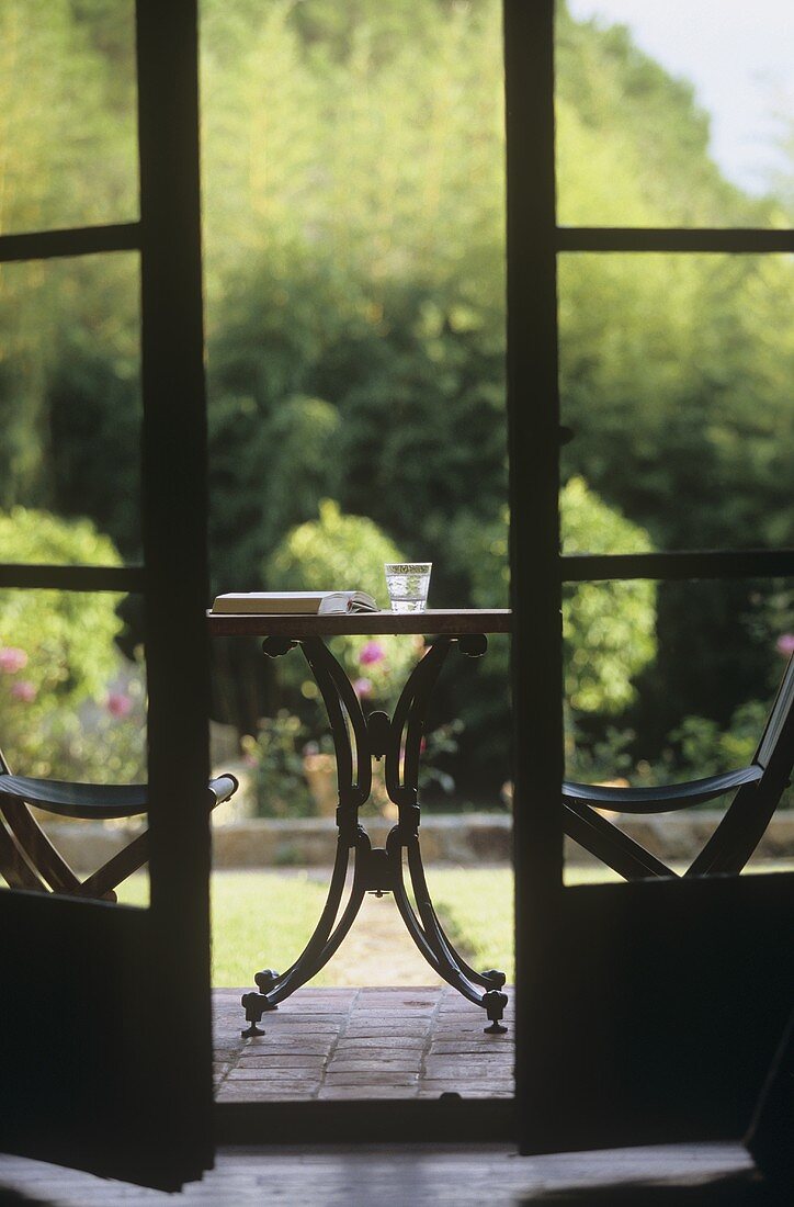 Glass of water and book on garden table