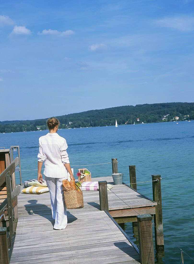 Frau mit Picknicktasche am Seeufer