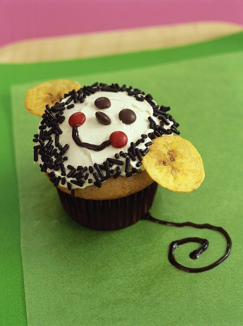 Cupcake mit lustigem Gesicht und Bananenchips für Kinder
