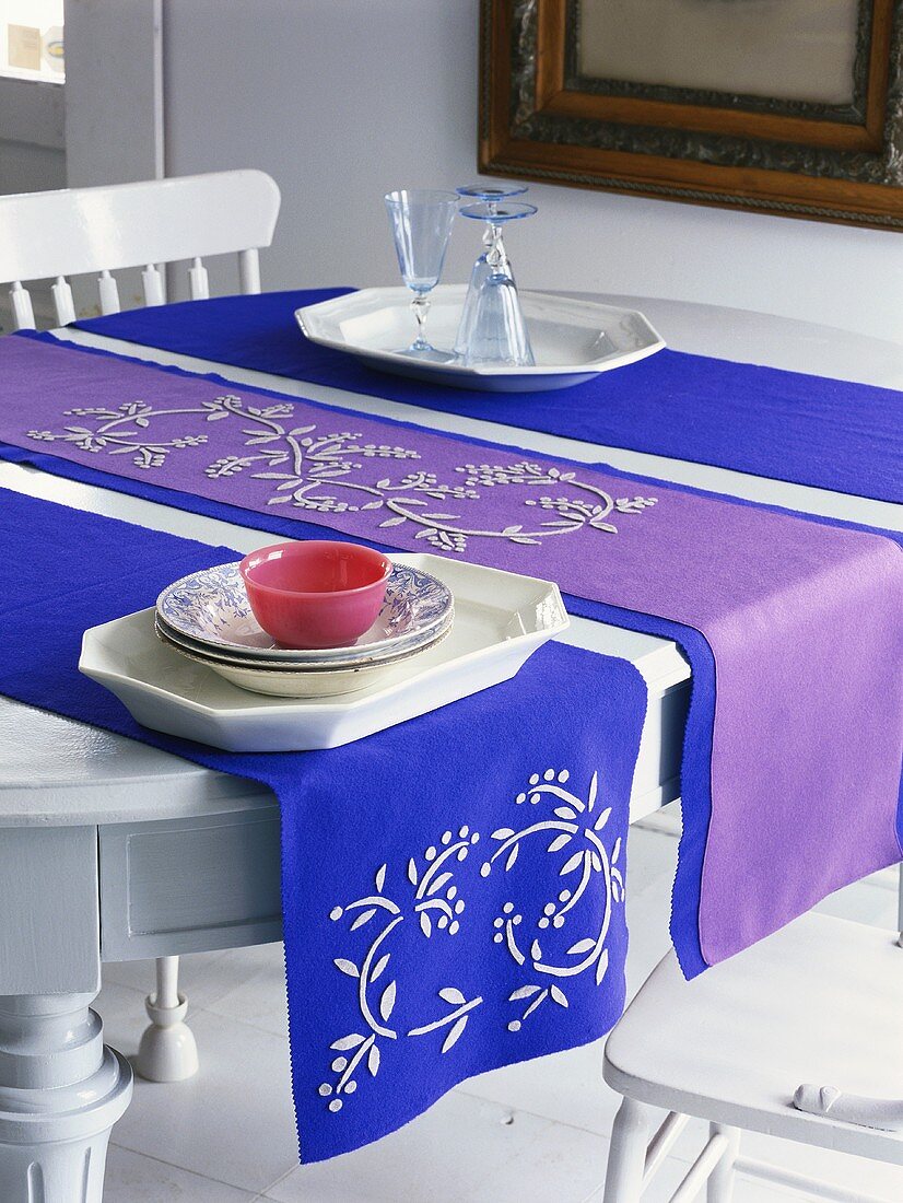 Blaue und violette Tischläufer, Geschirr und Gläser