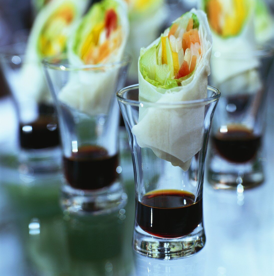 Reispapierröllchen mit Gemüsefüllung in Gläsern mit Sojasauce