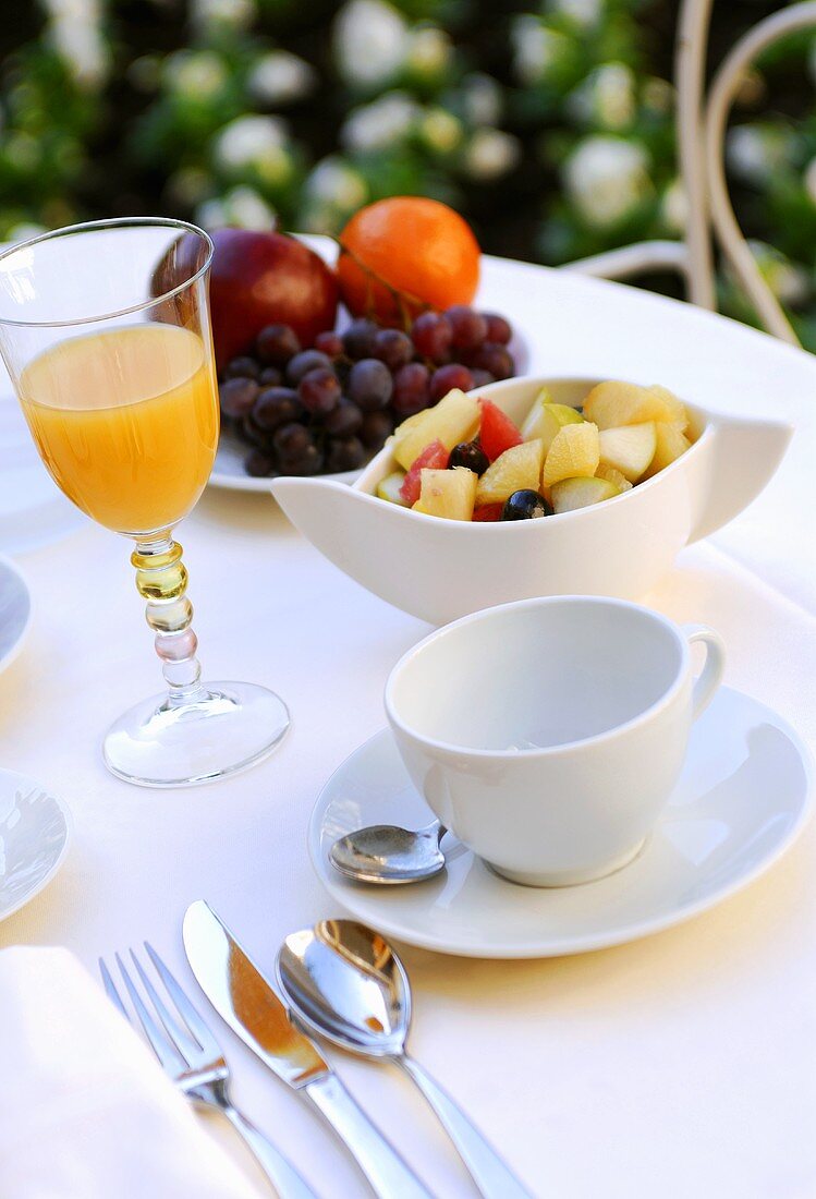 Frühstück mit Obstsalat, Orangensaft und frischen Früchten