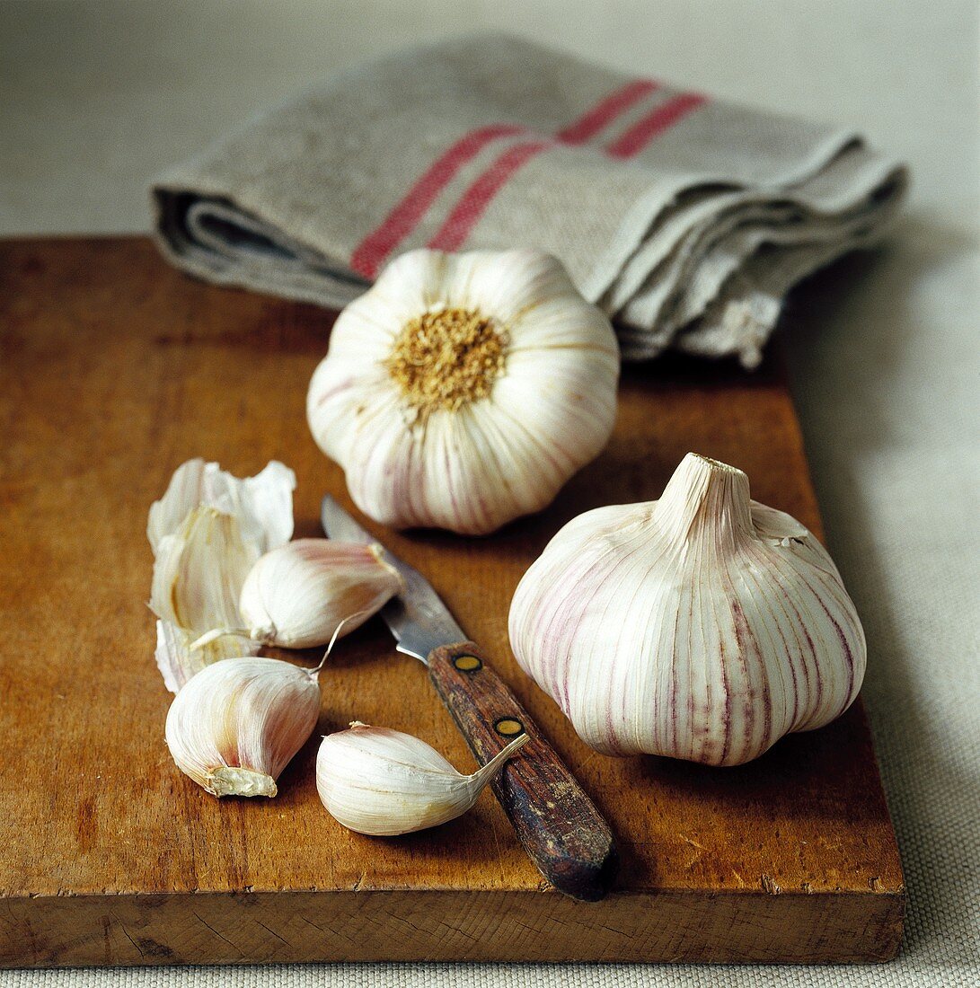 Garlic bulbs and cloves on wooden board
