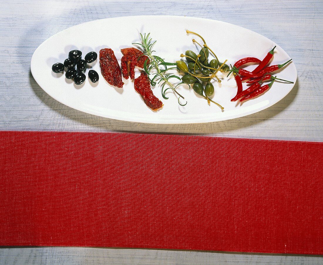 Still life with olives, dried tomatoes, capers and chili