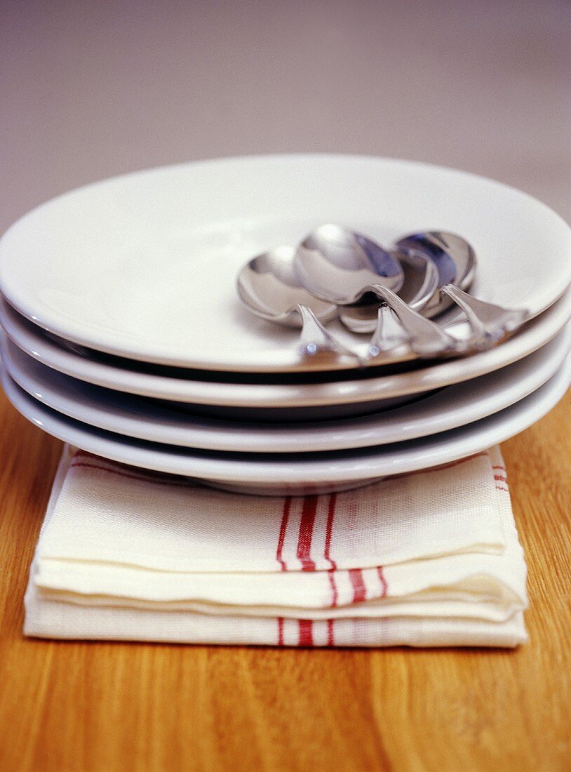 Pile of plates with spoons