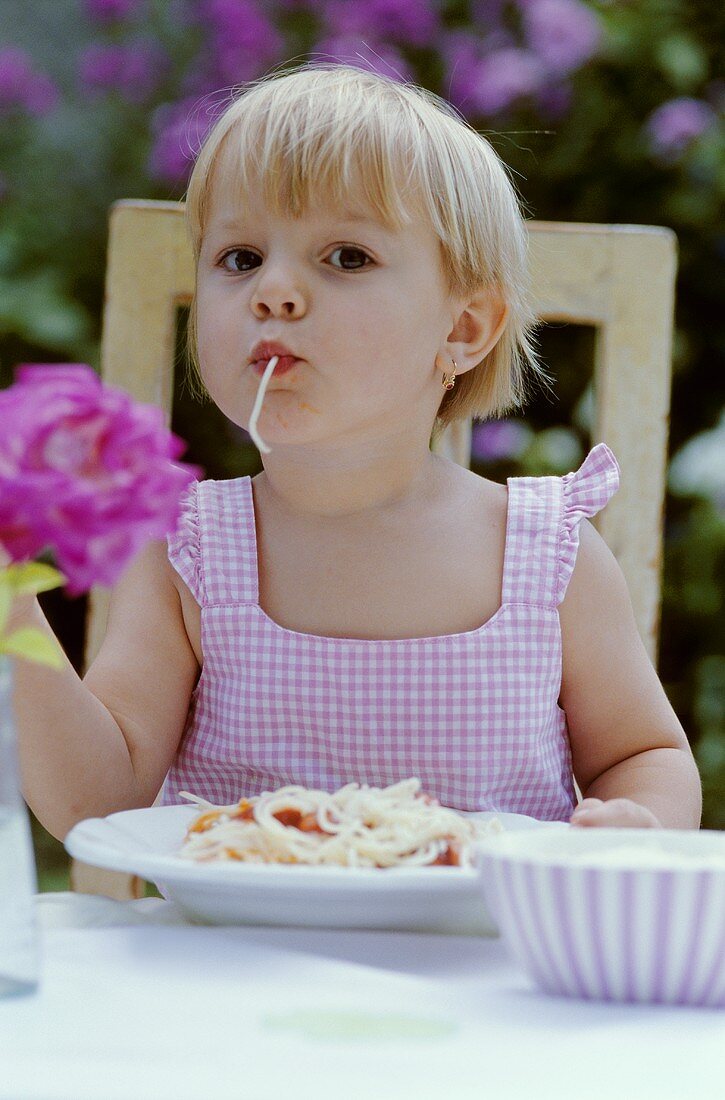 Kleines Mädchen mit Spaghetti im Mund